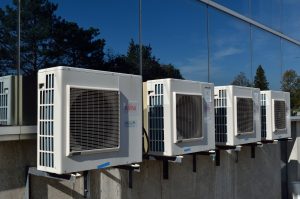 A photograph of some air conditioner units stationary outside of a building